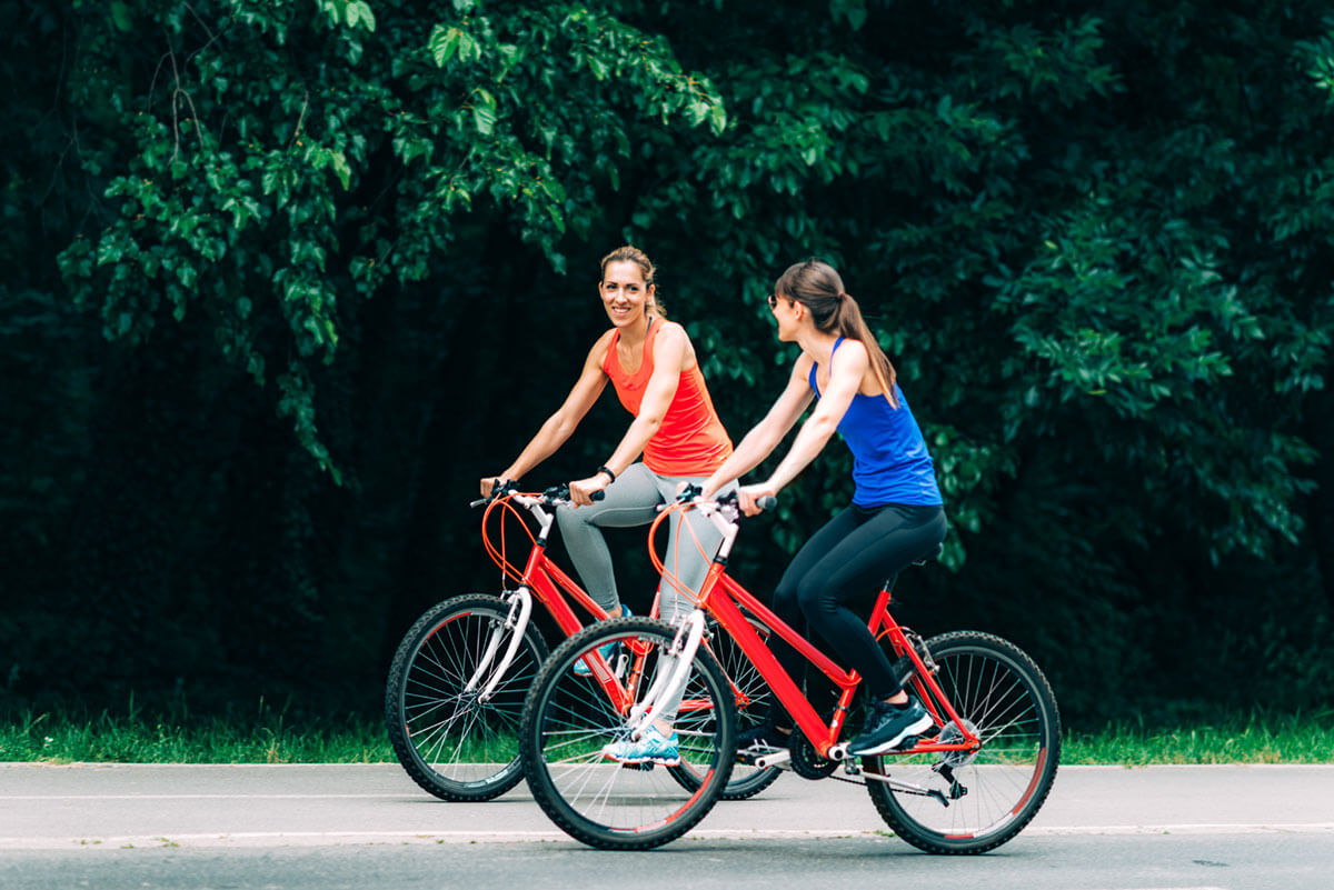 Women Riding Bikes Together In A Park